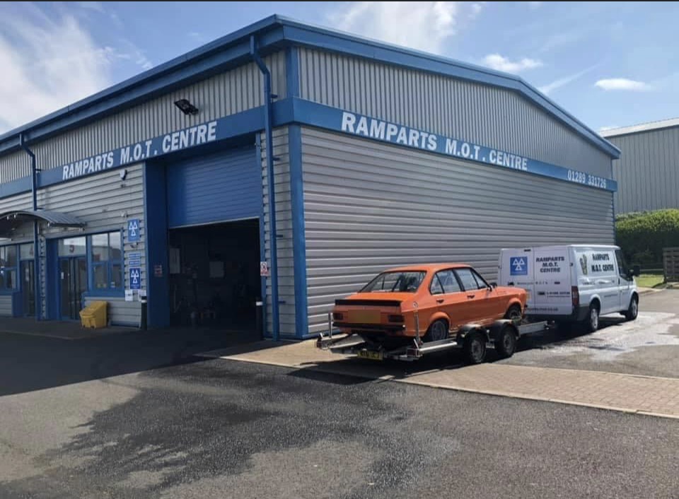 The Ramparts M.O.T. Centre building with its blue fascia, open workshop door and the Ramparts van outside