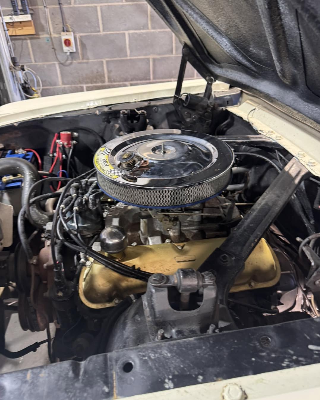 The engine bay of a 1965 Ford Mustang in for service at Ramparts