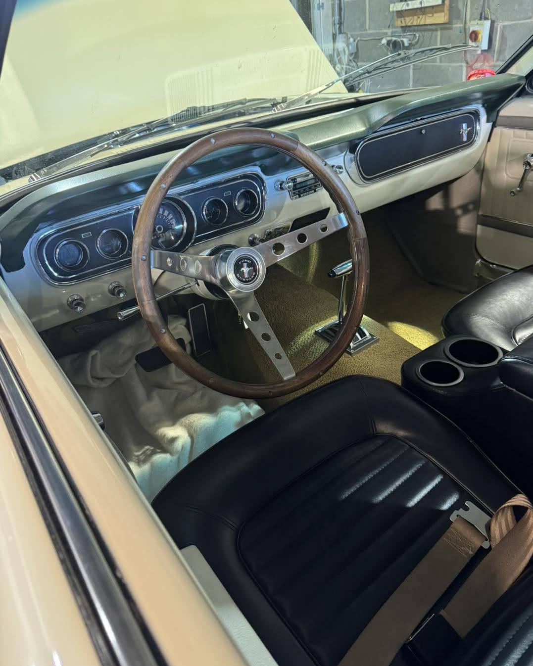 The dashboard and wood-rimmed steering wheel of the 1965 Ford Mustang